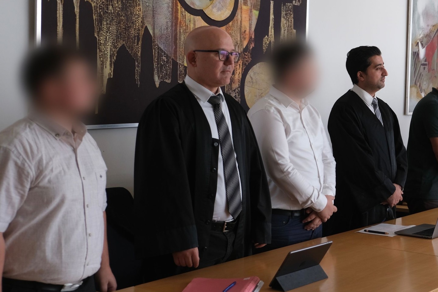 Zwei Angeklagte mit ihren Anwälten Cem Kilic (2.v.l.) und Zubair Khan (r) im Gerichtssaal in Lünen.