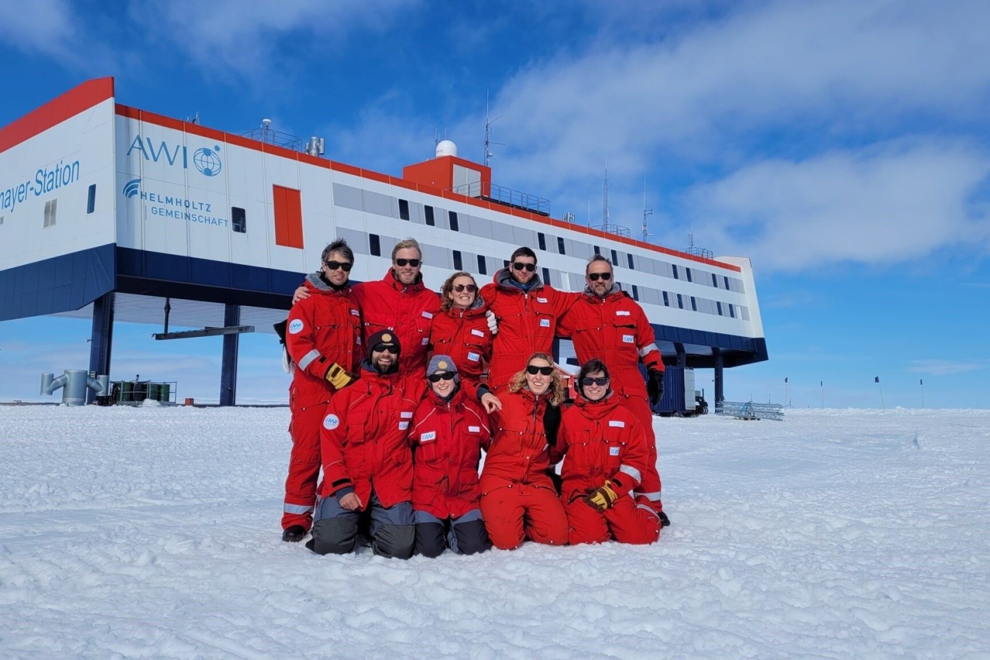 Das neunköpfige Überwinterungsteam posiert vor der Forschungsstation Neumayer III in der Antarktis.