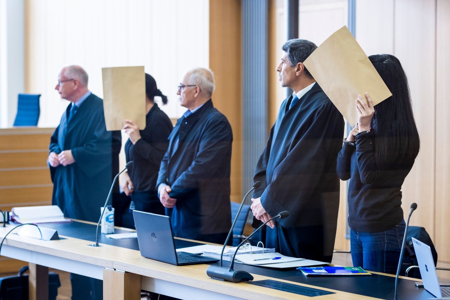Die angeklagten Frauen stehen beim Prozessauftakt in einem Saal des Landgerichts Braunschweig.