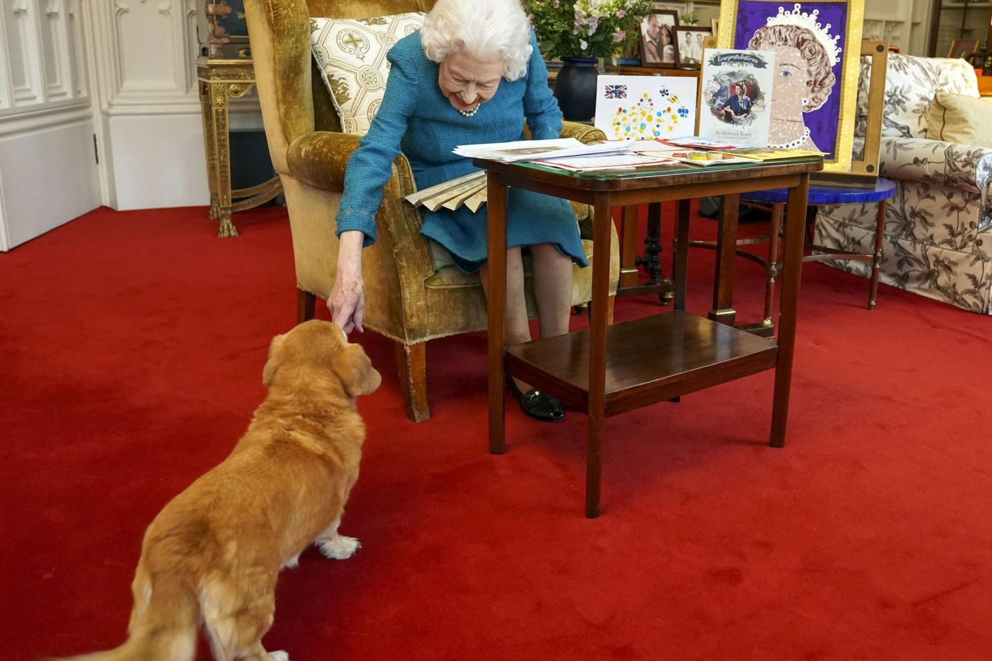 Königin Elizabeth II. streichelt einen ihrer Hunde, einem Corgi namens Candy, in Schloss Windsor.
