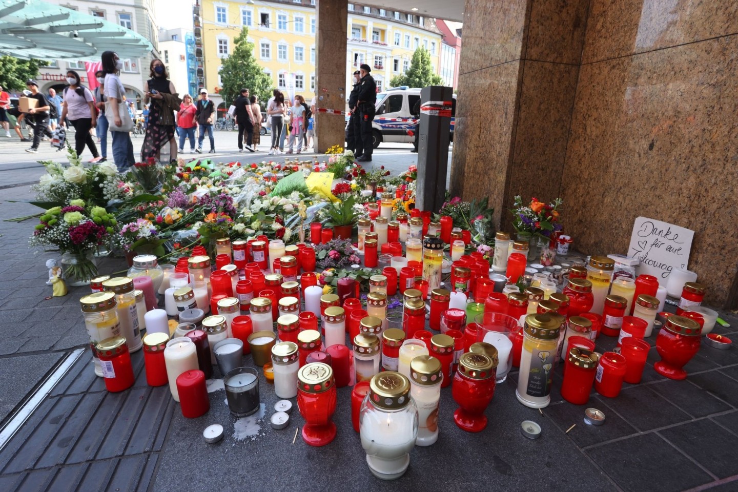 Blumen und Kerzen vor dem abgesperrten Kaufhaus in der Würzburger Innenstadt für die Opfer nach einer Messerattacke.