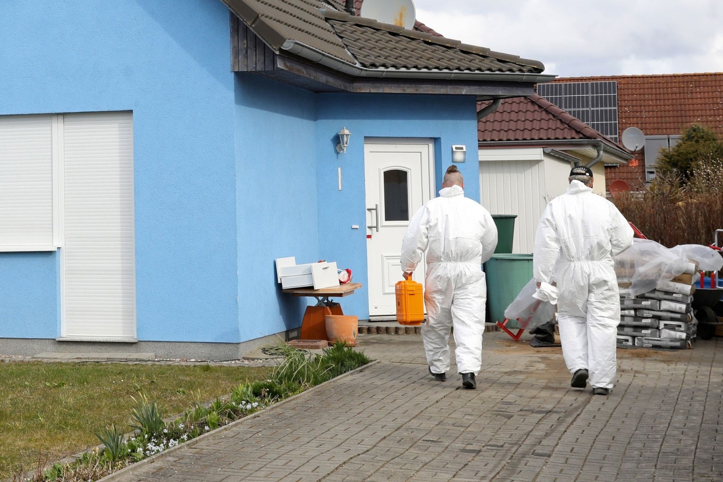 Mitarbeiter der Kriminaltechnik gehen in das Haus in Rövershagen, in dem drei Menschen getötet wurden (Archivbild).