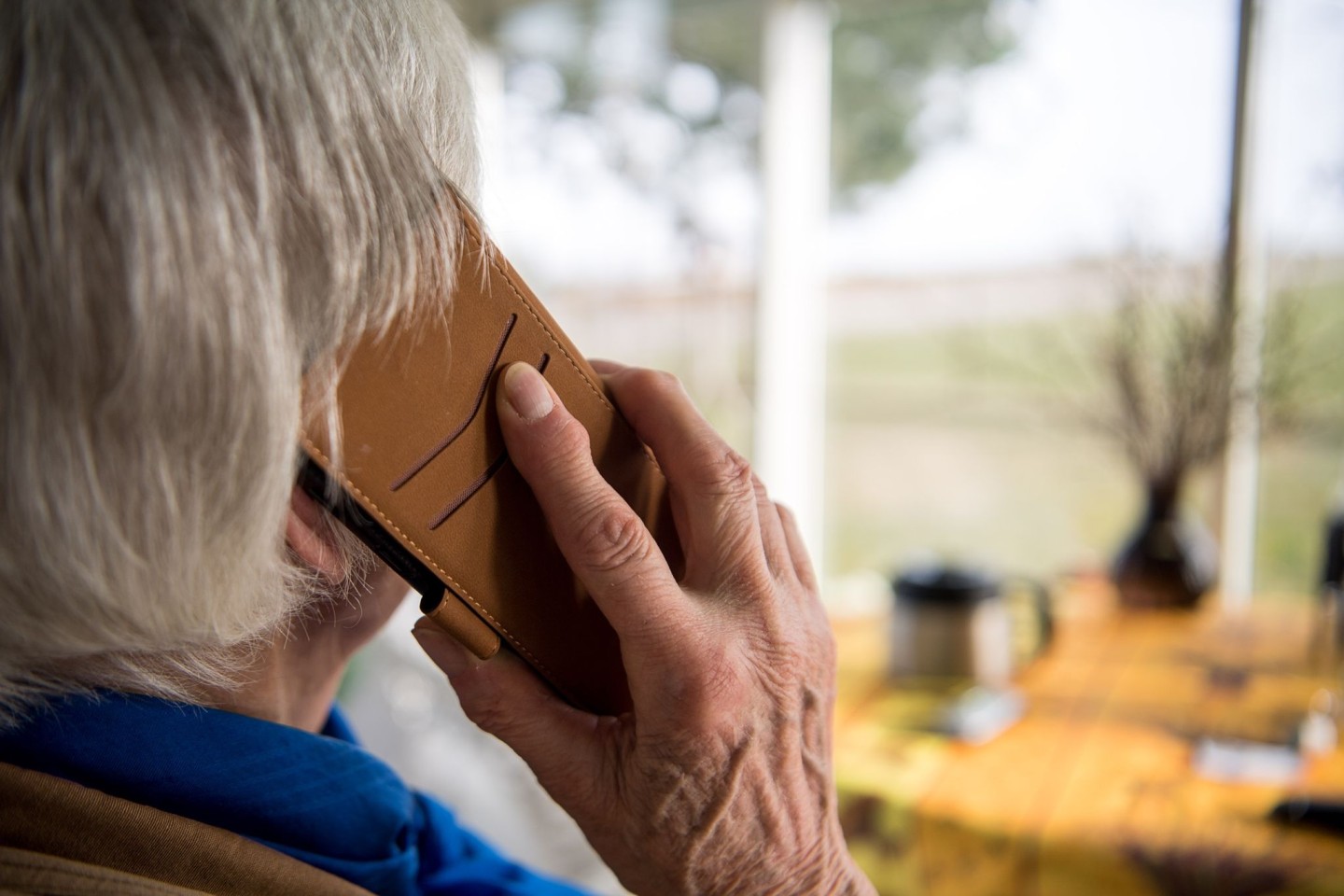 Eine alte Frau telefoniert. Telefonbetrüger überrumpeln gern mit falschen Geschichten und ergaunern viel Geld. (Symbolbild)